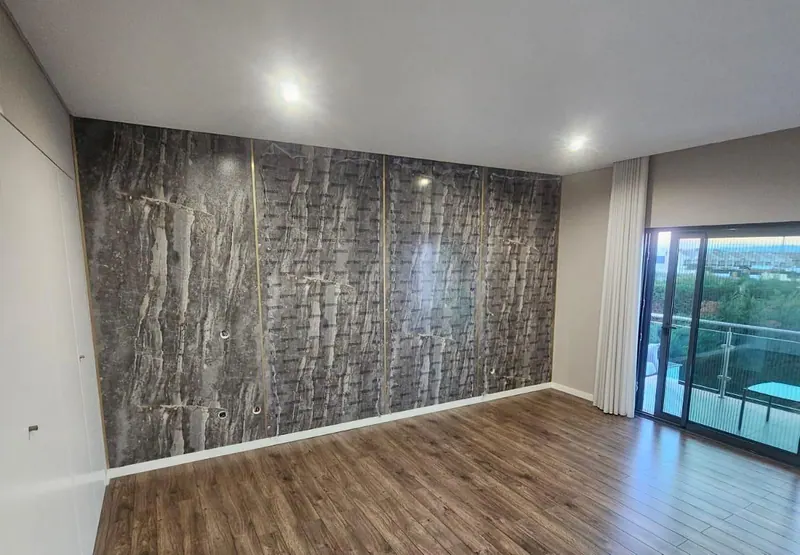 Habitación con pared de revestimiento efecto piedra y suelo de madera clara